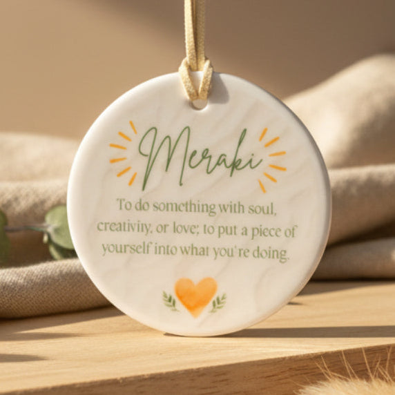 Round decorative item with 'Meraki' text and design on a beige background