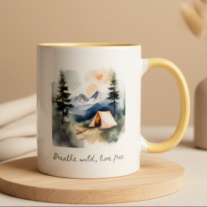 Mug with nature-themed design and text 'Breathe wild, live free' on a wooden surface.