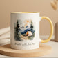 Mug with nature-themed design and text 'Breathe wild, live free' on a wooden surface.